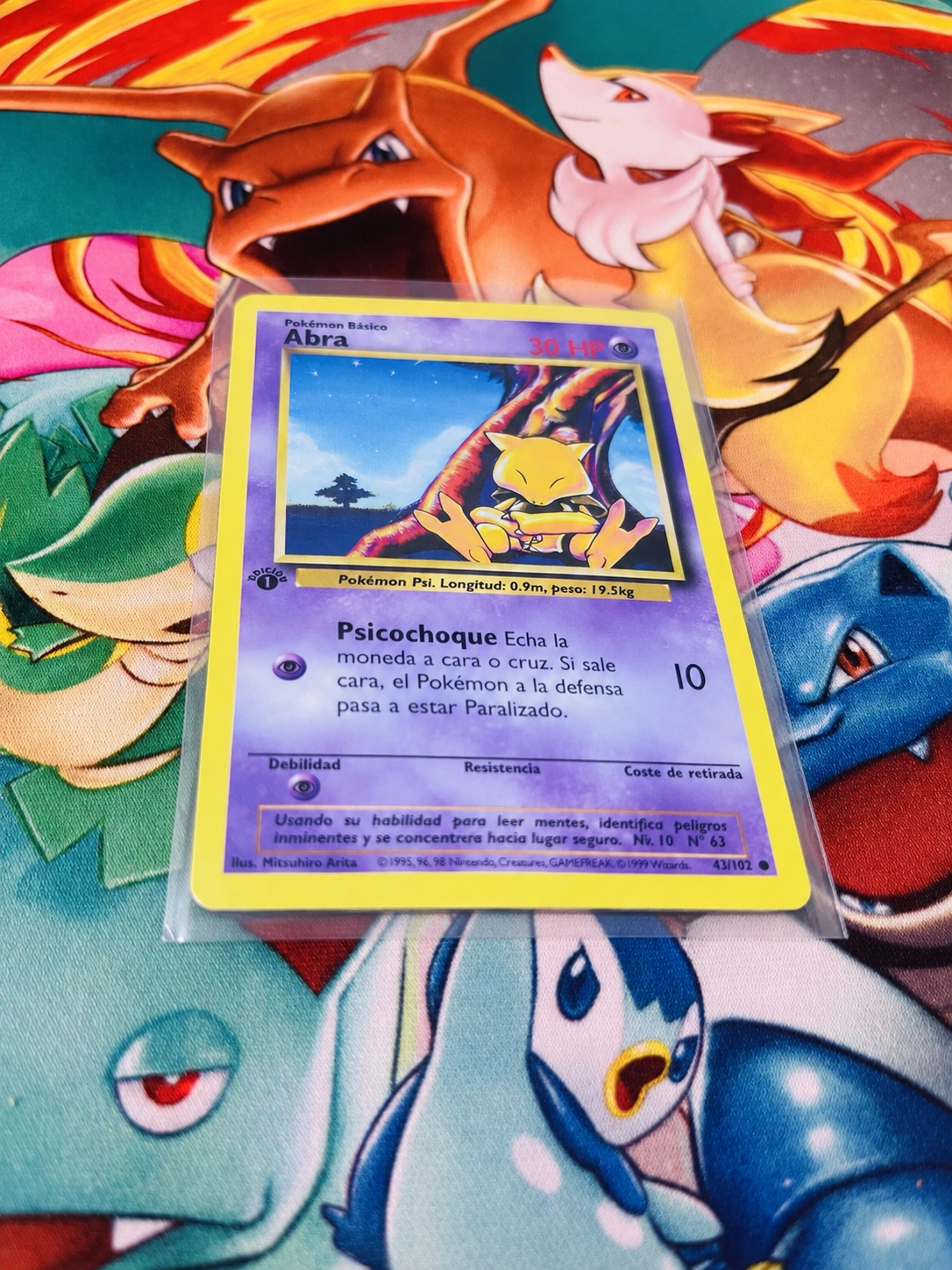 Abra Base Set 1.ª edición española en composición sobre tapete Pokémon; consulta también las fotos originales